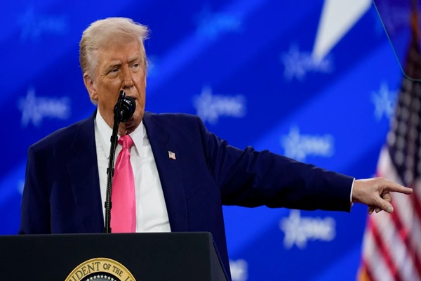 Trump revels in mass federal firings and jeers at Biden before adoring conservative crowd